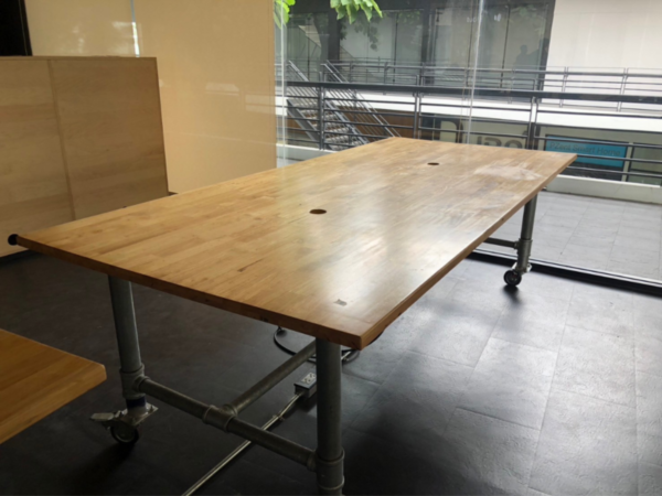 Work desk, 4 seats, steel frame, wood top, maple color, with wheels.