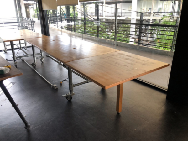 Work desk, 4 seats, steel frame, wood top, maple color, with wheels.