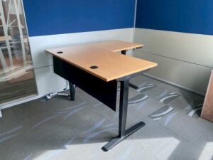 Uplift Desk, adjustable standing desk, L-shaped, black steel legs, with power strip, 150 cm wide.