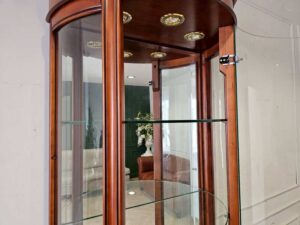 Glass display case with curved glass doors and a classic wooden frame.