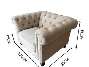 Chesterfield style armchair with cream-colored fabric and button tufting. (1)