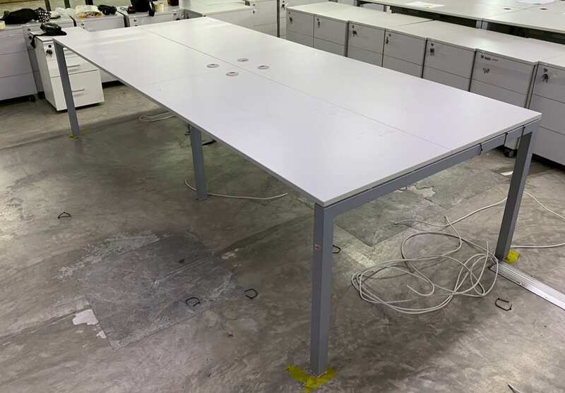 4-seater group workstation with grey steel legs and power strip.