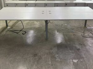 4-seater group workstation with grey steel legs and power strip.