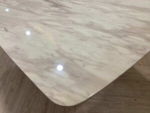 Dining table with stainless steel legs, leather upholstery, marble top