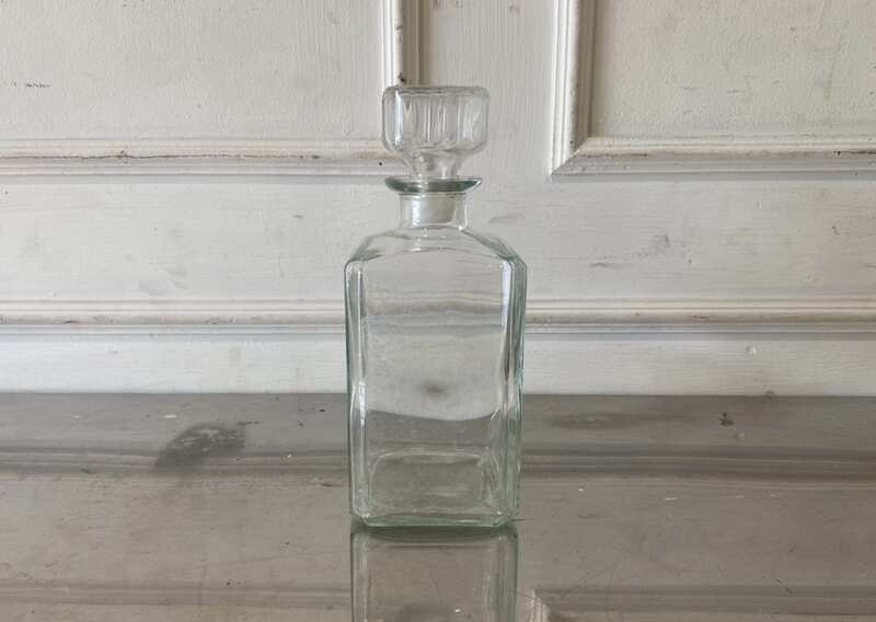 Square glass beverage bottle with a classic design.