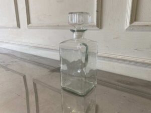 Square glass beverage bottle with a classic design.