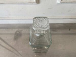 Square glass beverage bottle with a classic design.