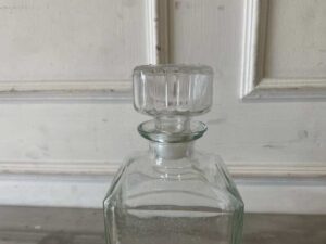 Square glass beverage bottle with a classic design.
