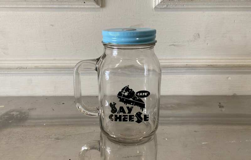 Clear glass mason jar with handle and lid.