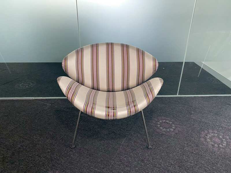 Guest chair with metal legs and cream fabric seat.