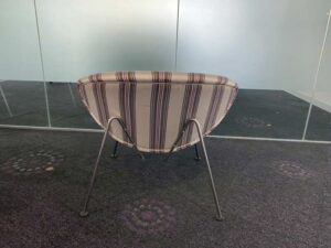 Guest chair with metal legs and cream fabric seat.