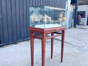 Glass display case with wooden legs and 1 sliding track. Wood color.