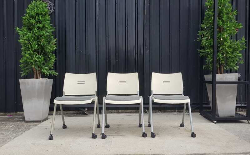 Chair with steel legs, casters, and a gray fabric cushion.