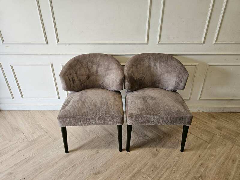 Dining chair with gray velvet upholstery and wooden legs.