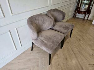Dining chair with gray velvet upholstery and wooden legs.