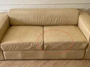 Two-seater sofa, cream leather upholstery.
