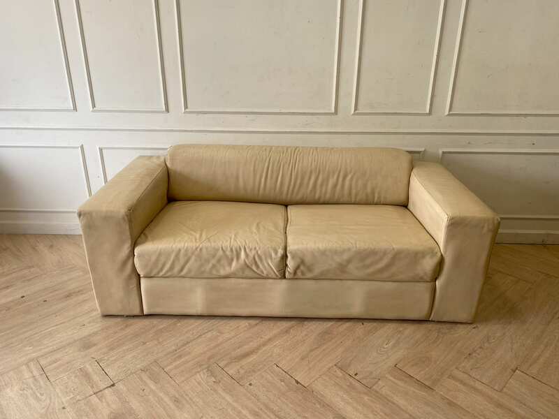 Two-seater sofa, cream leather upholstery.