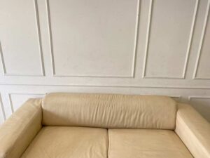 Two-seater sofa, cream leather upholstery.