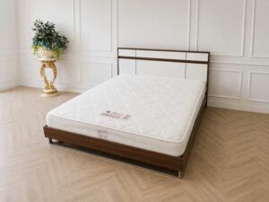 6-foot wooden bed frame with polished iron legs in a brown wood grain pattern, and a 6-foot white pocket spring mattress, Synda brand.