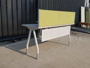 L-shaped corner desk with white steel legs and light yellow partition. 160 cm wide.