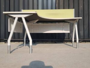 L-shaped corner desk with white steel legs and light yellow partition. 160 cm wide.