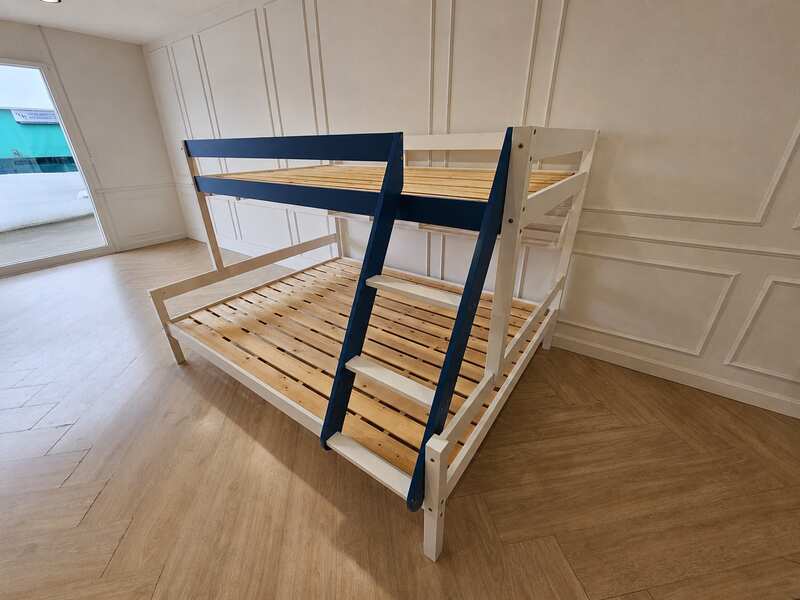White and blue wooden bunk bed for children with shelves.