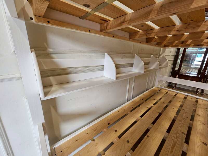 White and blue wooden bunk bed for children with shelves.