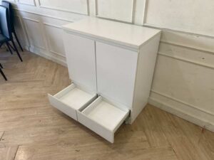 White wooden shoe cabinet with two doors and two drawers.