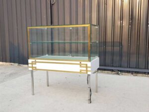 White glass display case with two doors and steel legs.