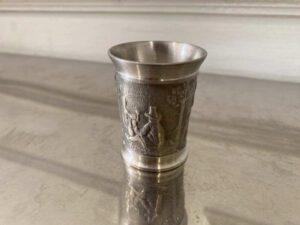 Drinking glass made of pure tin, with low-relief embossed patterns depicting daily life.