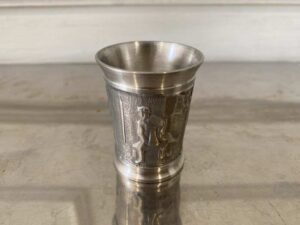 Drinking glass made of pure tin, with low-relief embossed patterns depicting daily life.