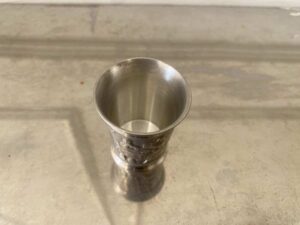 Drinking glass made of pure tin, with low-relief embossed patterns depicting daily life.
