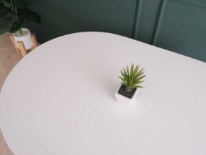 Central table, white wooden top, thick black steel frame, curved corners._88CU3KN5KJ