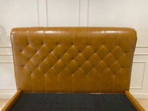 5-foot bed with leather cushions and brown button-tufted bolsters