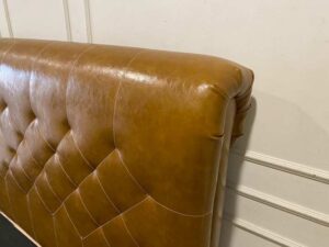 5-foot bed with leather cushions and brown button-tufted bolsters