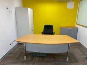 Curved-top office desk with light brown wood top and steel legs, MOFLEX brand.