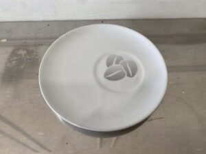 White ceramic coaster with coffee bean pattern, Costa Coffee brand.