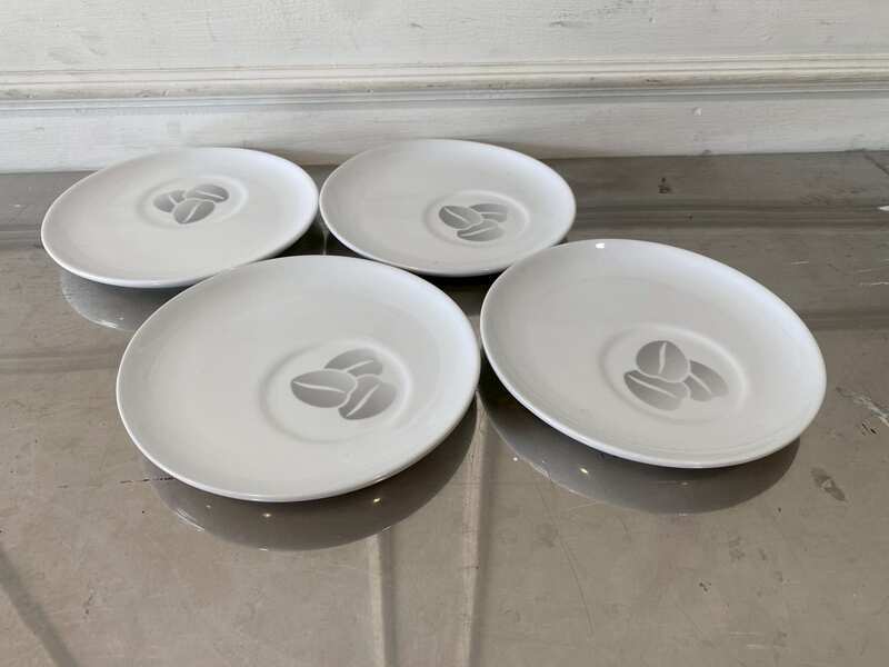 White ceramic coaster with coffee bean pattern, Costa Coffee brand.
