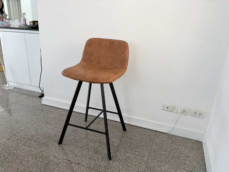 Brown leather bar stool with black wooden legs