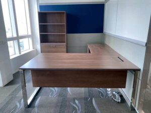 L-shaped corner desk with 3 drawers, steel legs, with rails, and power outlet.