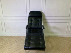 Facial massage bed, steel legs, black leather upholstery.
