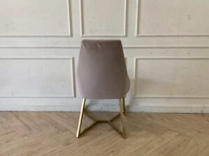 Chair with gold-colored metal legs and grey velvet seat.
