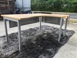 L-shaped work desk, gray steel frame, wooden top.