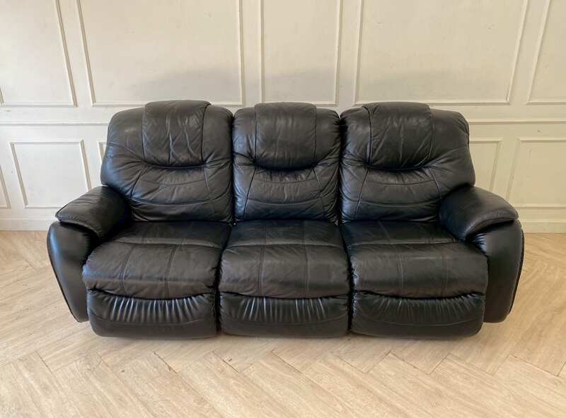 Black 3-seater leather sofa bed with a central cushion that folds down to become a cup holder._DDHQY5KRSU