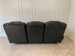 Black 3-seater leather sofa bed with a central cushion that folds down to become a cup holder._DDHQY5KRSU