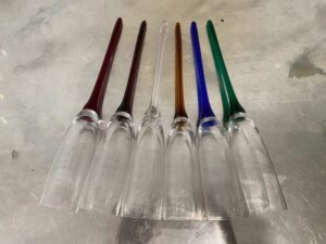 Vintage bohemian-style champagne glasses, tall with no base, long stems in various colors.