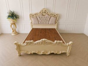 6-foot Louis XV bed with beige nude velvet headboard and carved floral frame.