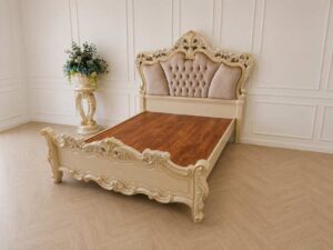 6-foot Louis XV bed with beige nude velvet headboard and carved floral frame.