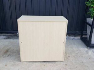 Cream-colored, wooden-framed filing cabinet with 2 sliding doors.