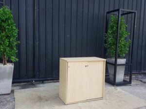 Cream-colored, wooden-framed filing cabinet with 2 sliding doors.